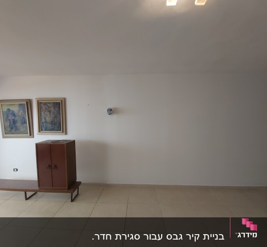 קיר גבס עם תמונות ותאורה עליונה
